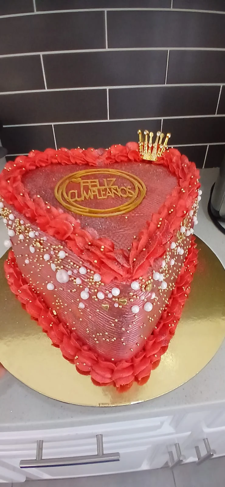 Queque rojo en forma de corazón y detalles de perlas